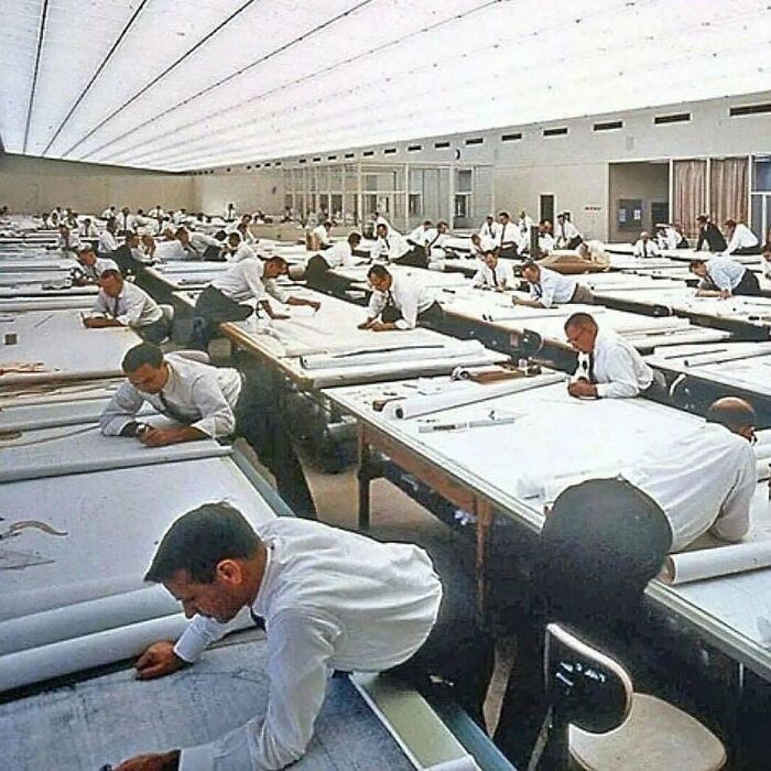 Hombres trabajando en planos en oficina amplia, ilustrando datos e historias interesantes respaldados con imágenes.