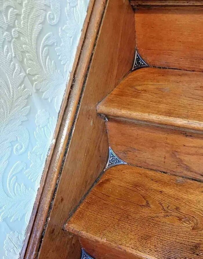 Escalera de madera con detalles en las esquinas y pared con textura, ilustrando datos e historias interesantes.