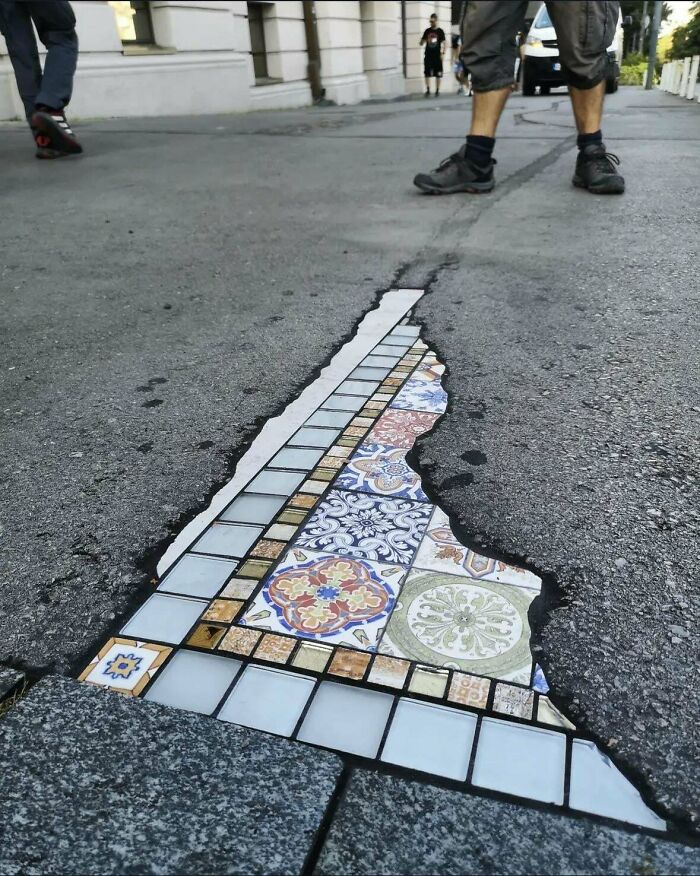Datos interesantes del mundo con mosaicos coloridos decorando un parche en el pavimento de la calle.