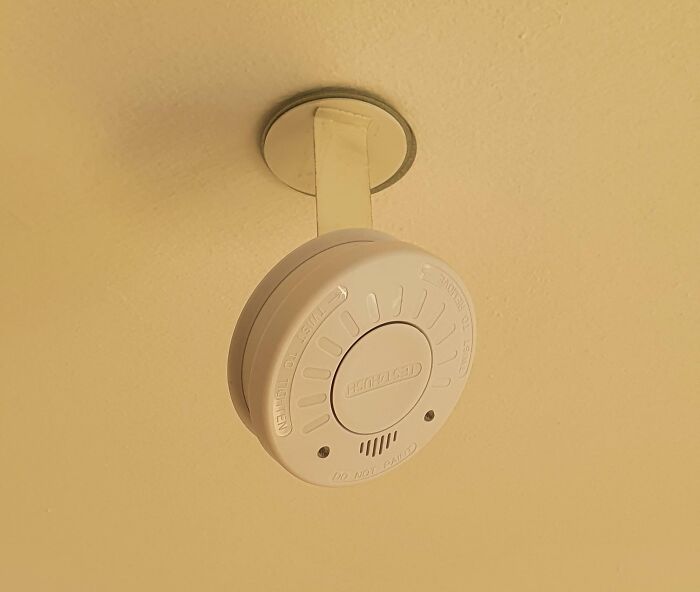 Detector de humo blanco instalado en techo con consecuencias visibles tras olas de calor veraniegas en la vivienda.