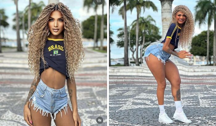 Mujer con cabello rizado, camiseta Brasil y shorts, posando al aire libre en un lugar tropical junto a palmeras.