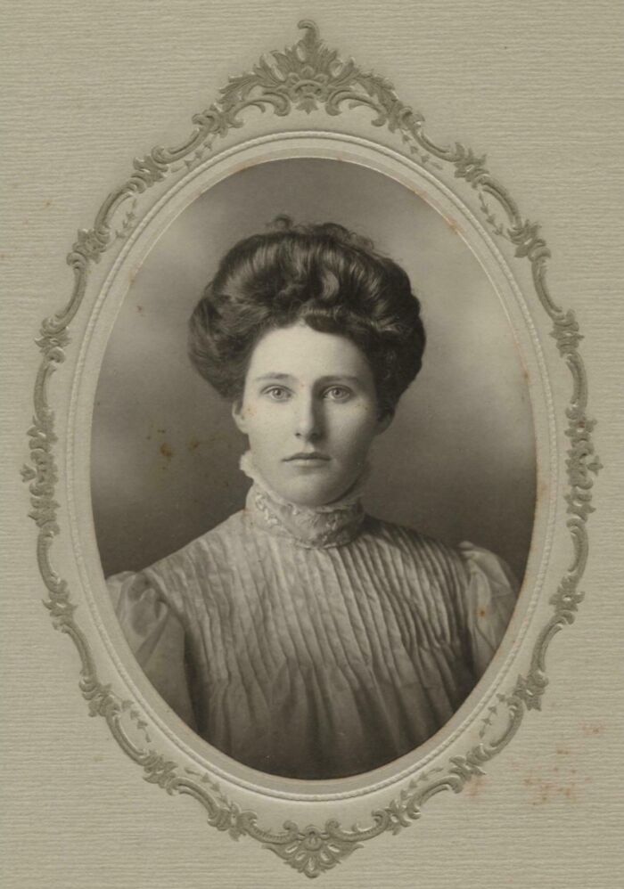 Retrato en blanco y negro de mujer con peinado antiguo y vestido clásico en marco oval vintage, foto histórica fascinante.