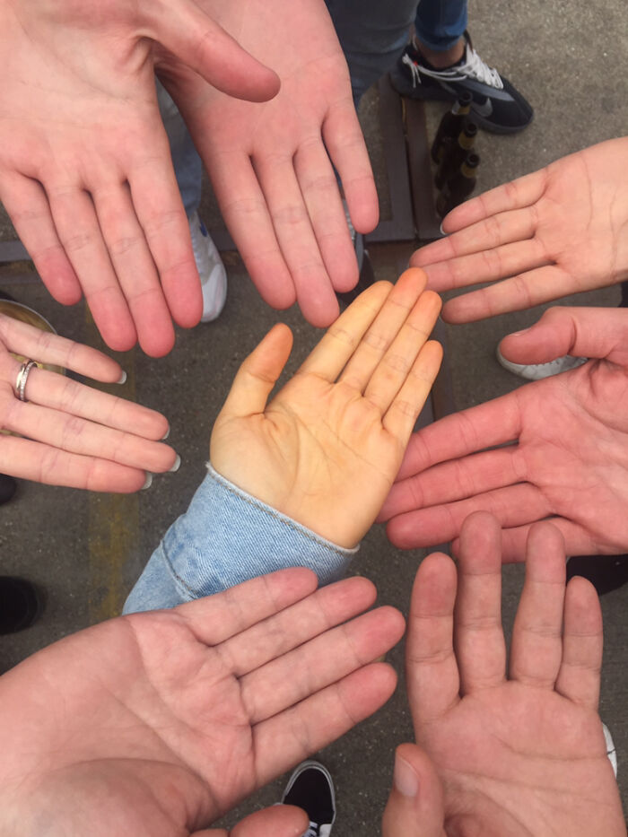 Manos humanas extendidas en círculo mostrando rasgos distintivos del cuerpo humano que hacen destacar a la gente.