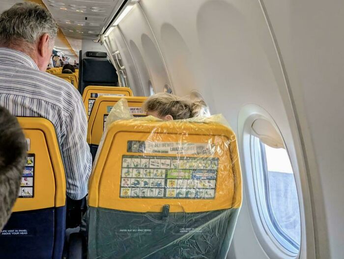 Pasajera prepotente en avión con asiento cubierto en plástico causando molestia a otros viajeros.