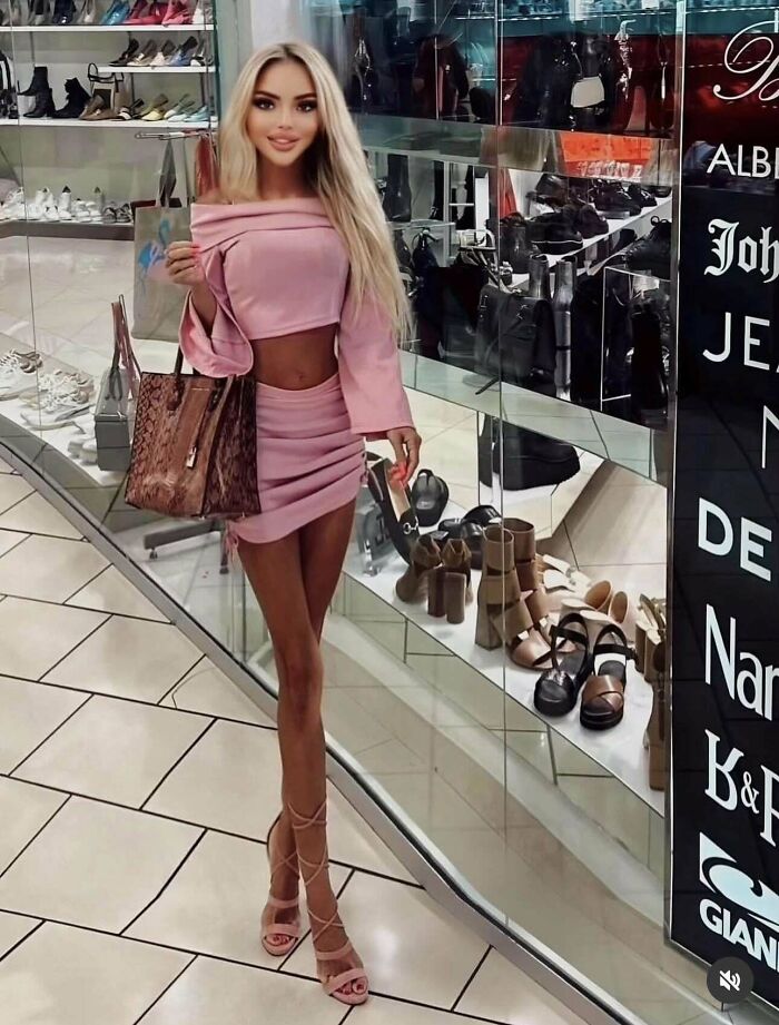 Mujer posando en centro comercial con vestido rosa y bolso grande, ejemplo claro de instagram colapsó bajo la realidad.
