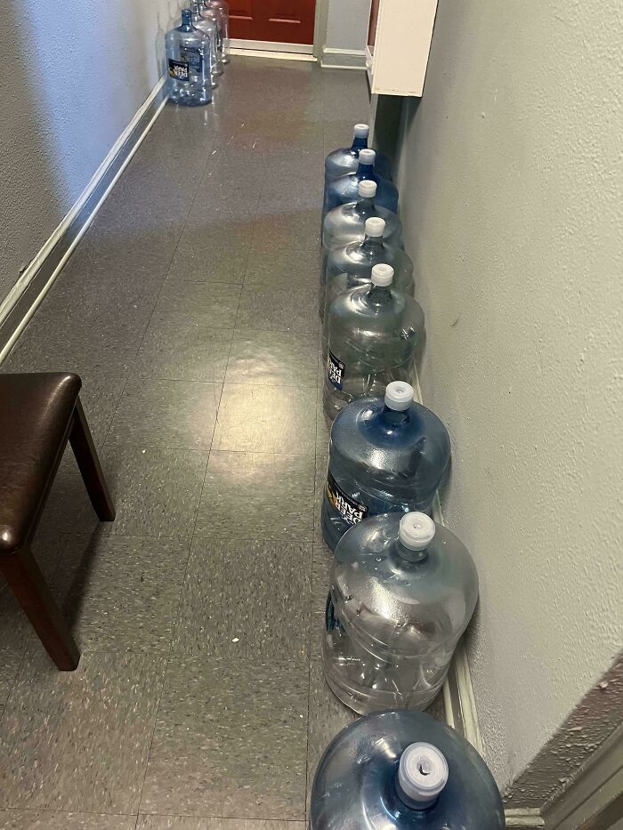 Botellones de agua vacíos alineados en pasillo, reflejando personas prepotentes actuando con derecho exagerado.