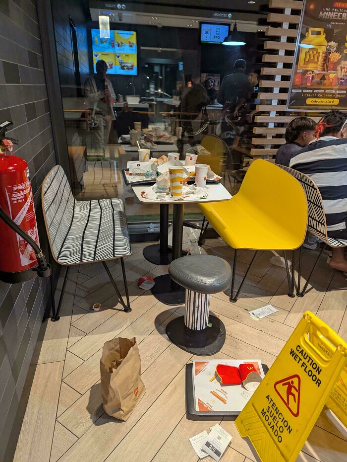 Restos de comida y basura en restaurante, ejemplo de personas prepotentes mostrando desorden y falta de respeto.