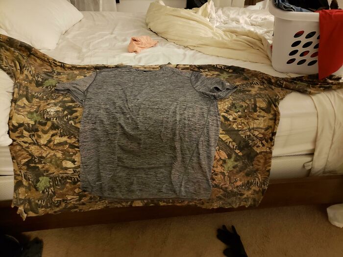 Camisetas de diferentes tamaños extendidas en una cama, mostrando la diversidad inesperada en la vida diaria.