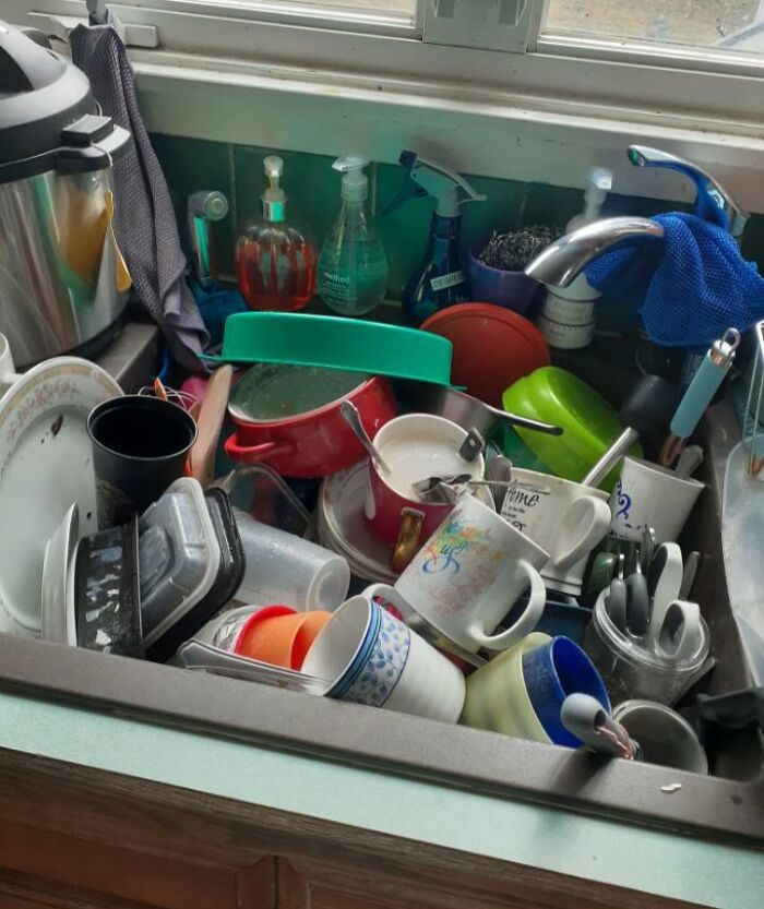 Lavaplatos lleno de trastes sucios acumulados, mostrando el desorden típico con un hermano consentido en casa. Lavaplatos lleno de trastes sucios acumulados, mostrando el desorden típico con un hermano consentido en casa.