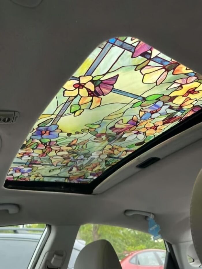 Luz solar en techo corredizo de coche con diseño casero de vitral floral, proyecto casero con ejecución fallida evidente.