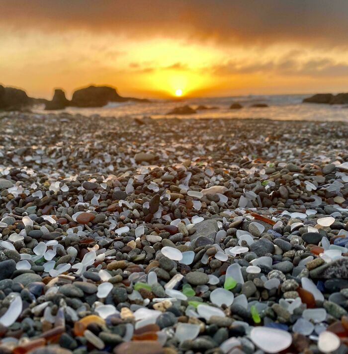 Puesta de sol en la playa con cristales y piedras, una de las veces que la gente encontró algo inesperado en la playa.