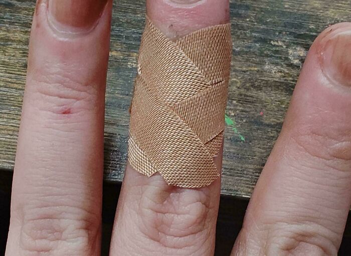 Dedo con curitas cruzadas como uno de los life hacks más ingeniosos que la gente usa para protección rápida y eficaz.