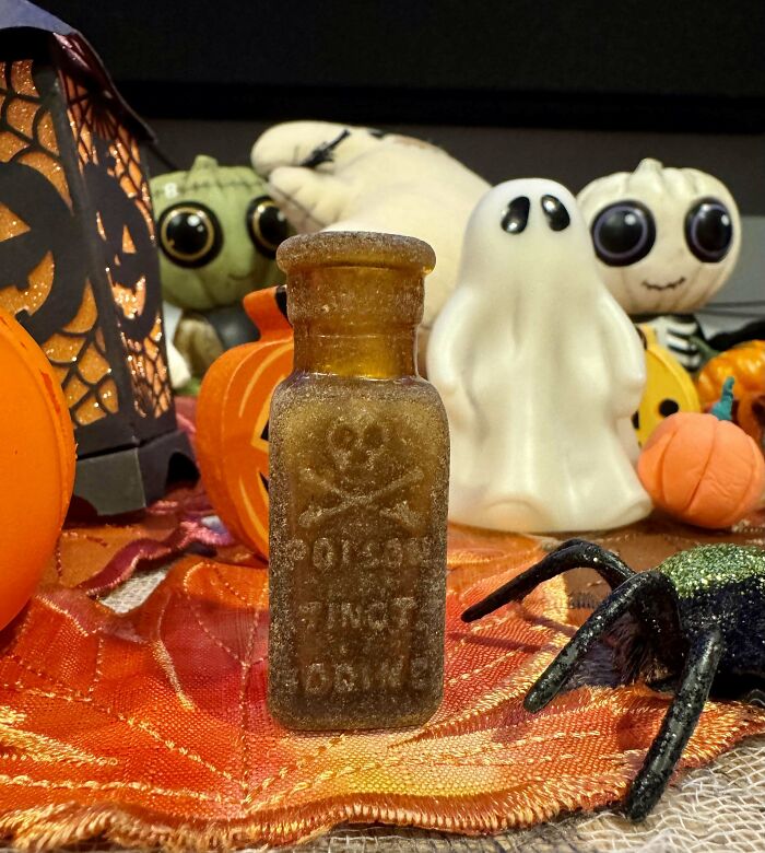 Frasco antiguo con calavera entre decoraciones de Halloween, un hallazgo inesperado en la playa según fotos recientes.