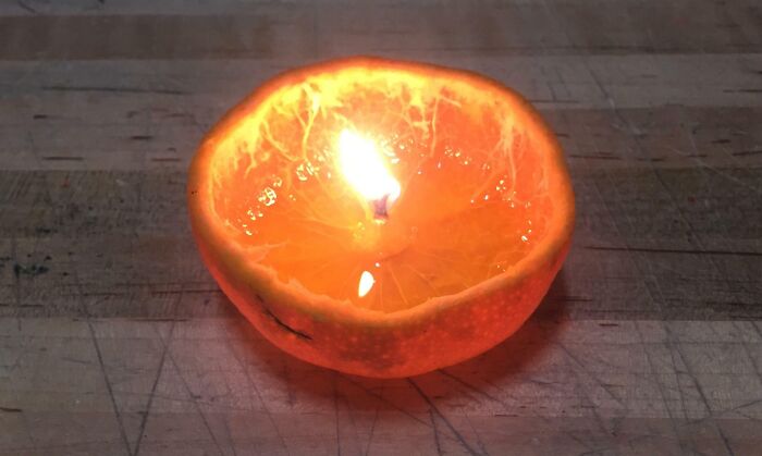 Fragancia natural hecha con trucos ingeniosos para la vida usando una cáscara de naranja como vela encendida.