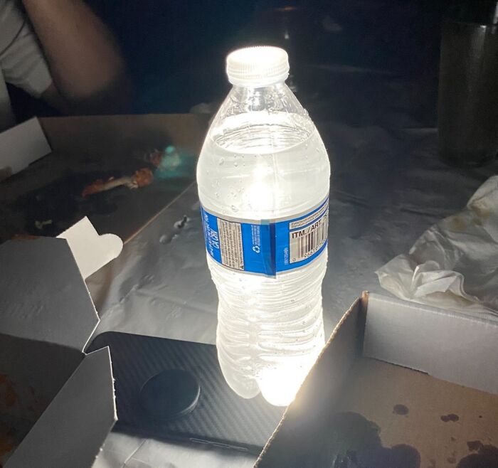 Botella de agua iluminada con luz detrás demostrando un life hack genial que la gente realmente usa.