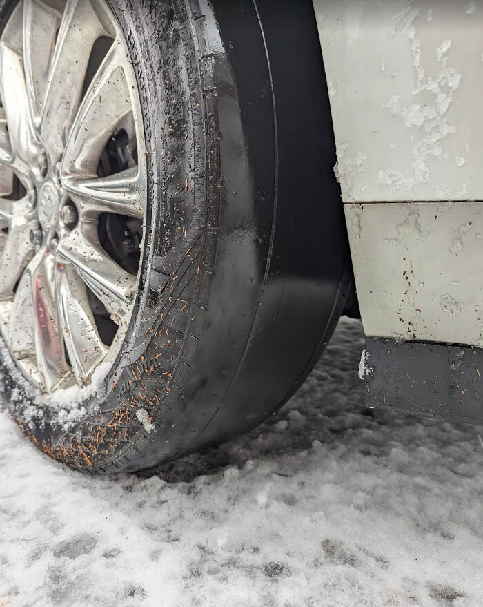 Neumático completamente desgastado en un coche, tema común en fotos de mecánicos para mostrar problemas reales.