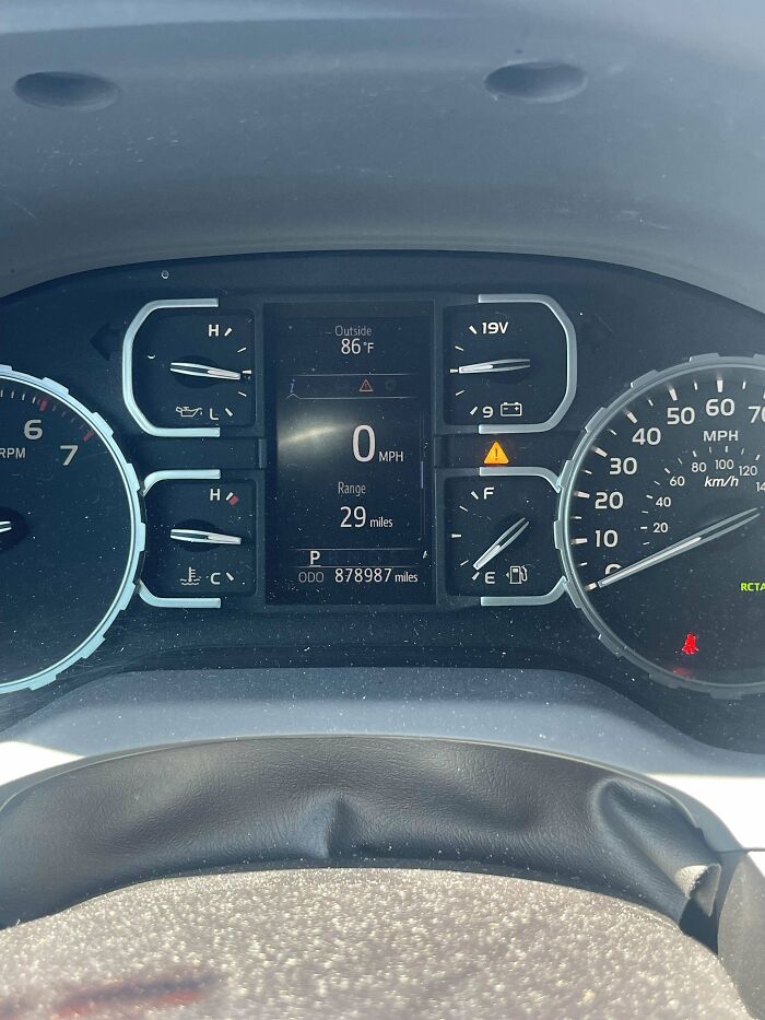 Tablero de vehículo con odómetro mostrando 878987 millas, imagen tomada por mecánico para mostrar lectura inusual del auto.