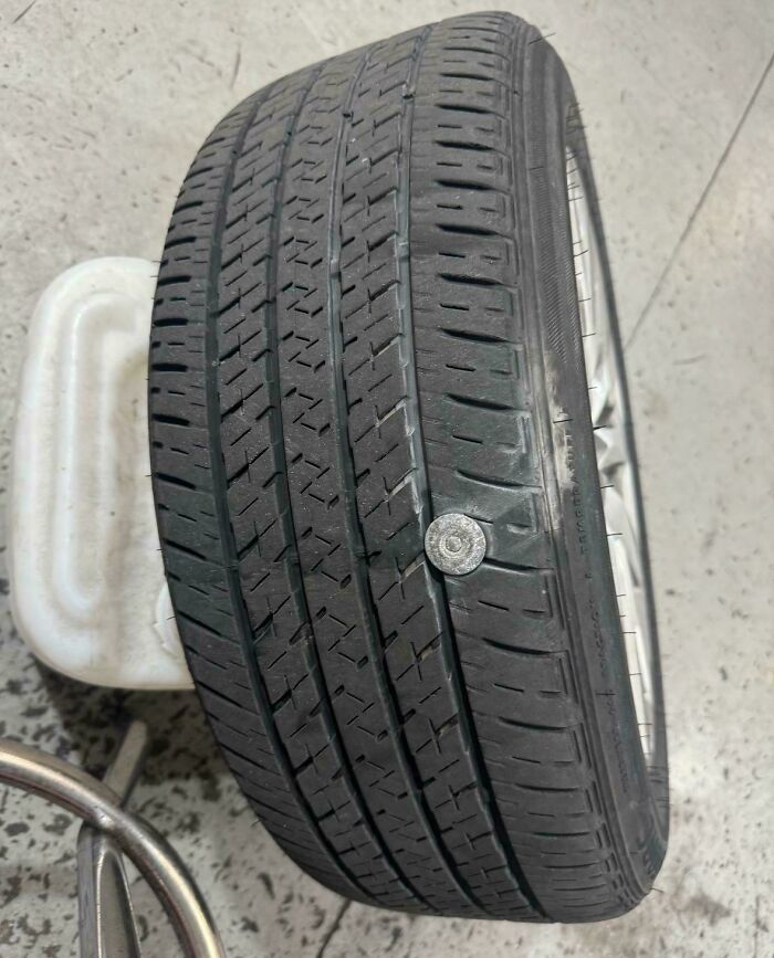 Llantas de coche con clavo incrustado, fotografía tomada por mecánicos para mostrar el daño real del neumático.