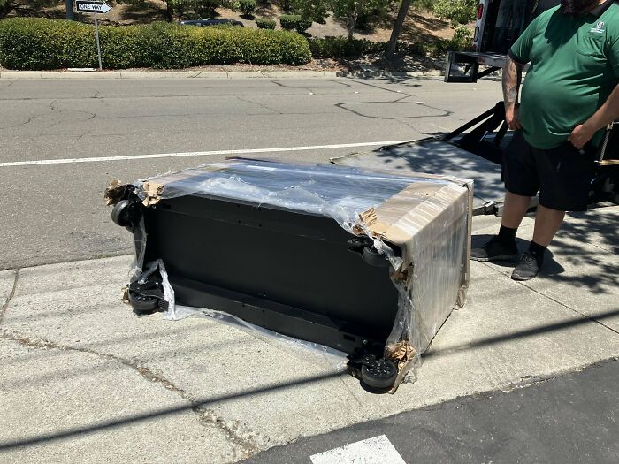 Mecánico de autos toma foto de pieza dañada envuelta en plástico para mostrar el daño visible y convencer a otros.