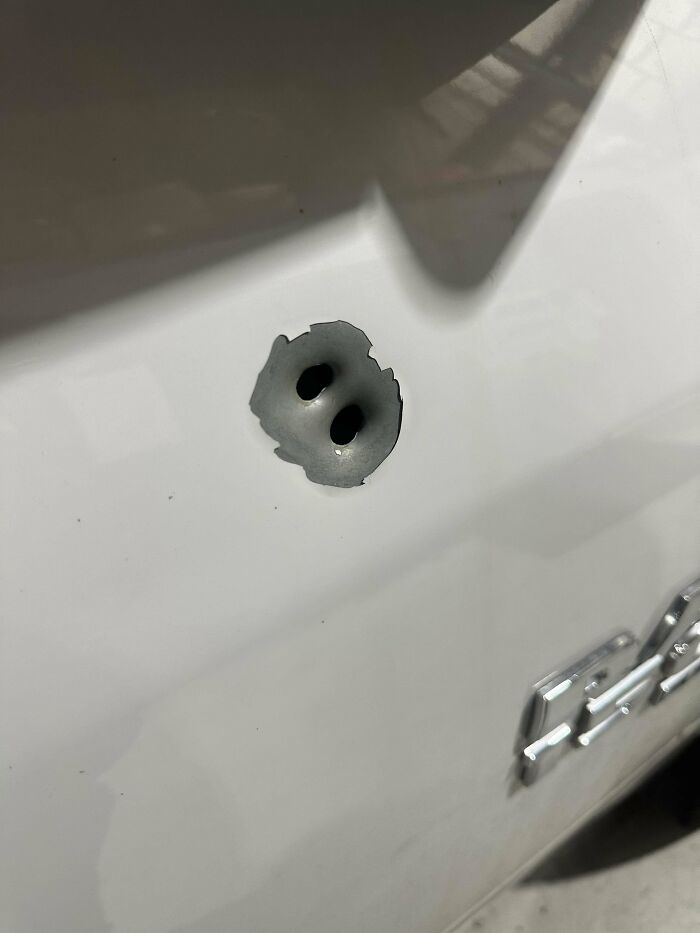Agujero inusual en la carrocería de un coche, imagen tomada por mecánicos para mostrar evidencia visual.