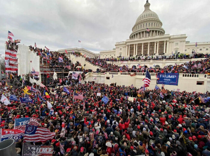 Multitud en el Capitolio con banderas estadounidenses en evento caótico donde las cosas no salieron como se planearon.