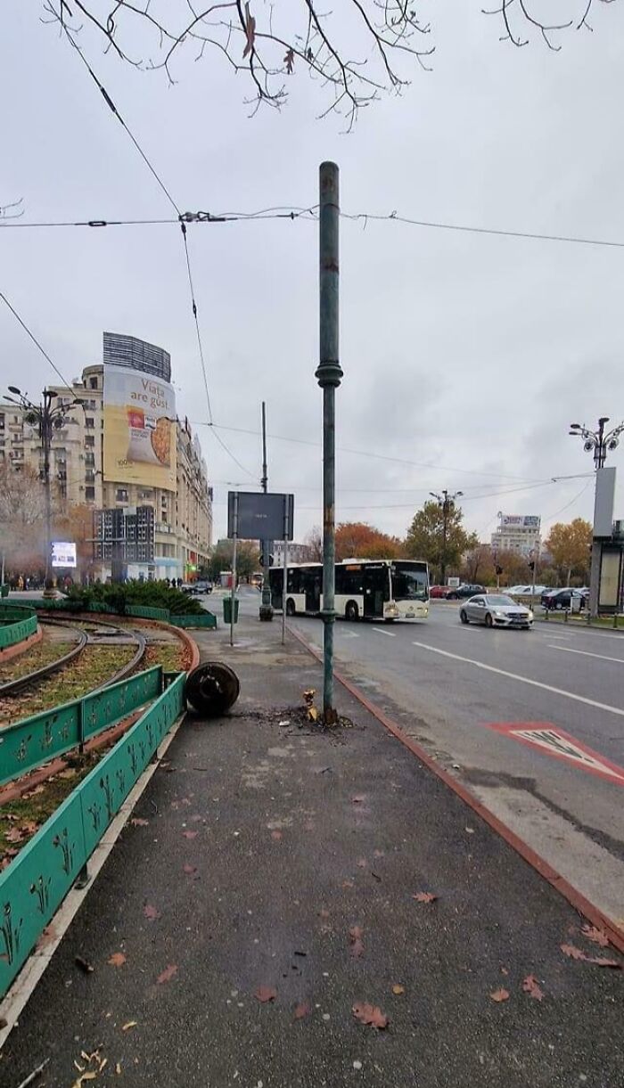 Fallo patético en la calle con poste mal ubicado y señalización confusa en zona urbana transitada.