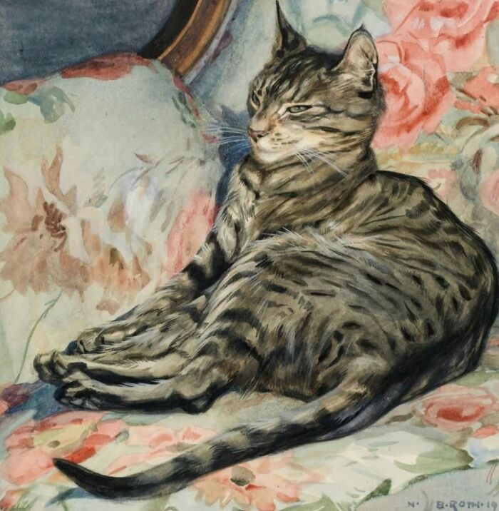 Gato atigrado descansando en sofá con flores, imagen adorable que muestra a gatos como protagonistas históricos.
