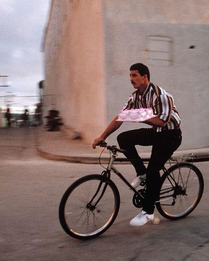Hombre en bicicleta con paquete, foto antigua con contexto histórico poco conocido en fotografía vintage urbana.