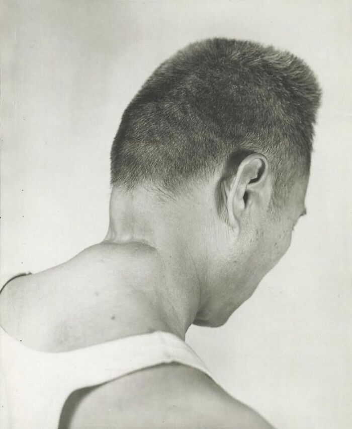 Hombre sonriente de perfil con corte de cabello corto en foto antigua en blanco y negro, fotos antiguas y contexto histórico.