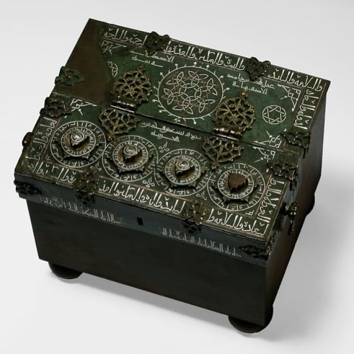 Caja antigua con inscripciones árabes y mecanismos giratorios, una fotografía histórica que revela contexto y secretos antiguos.