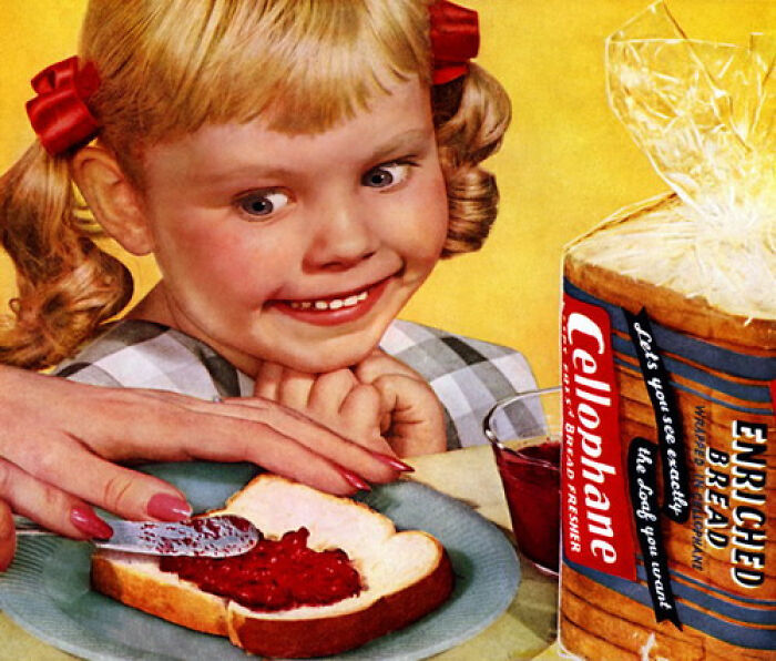Niña sonriente mirando mientras untan mermelada en una rebanada de pan en un anuncio vintage de normas culturales cambiantes.