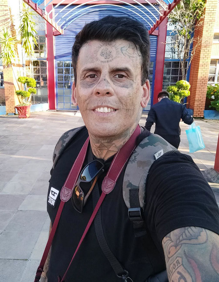 Hombre brasileño con 95% del cuerpo tatuado mostrando su impacto tras la eliminación de tatuajes con láser al aire libre.