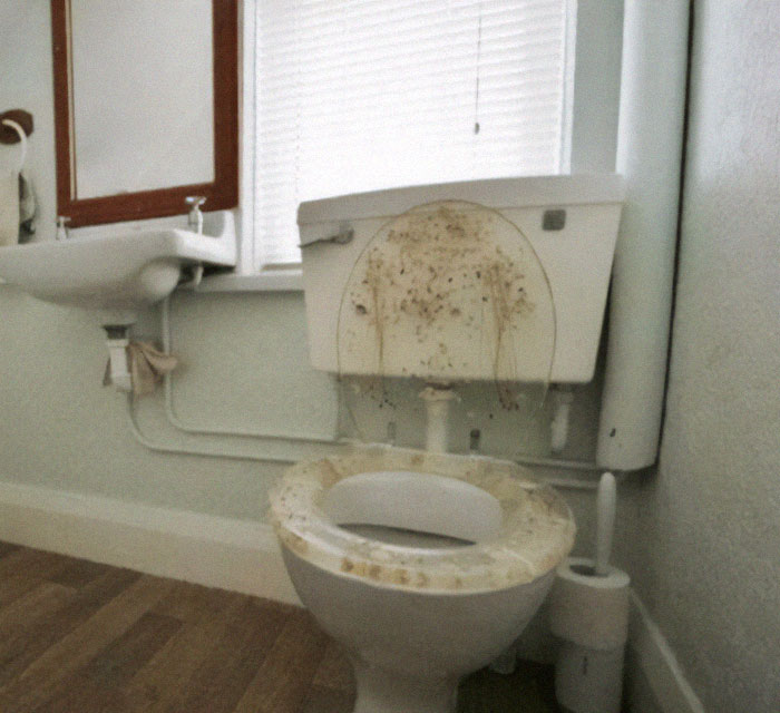 Inodoro viejo y sucio con evidentes fallos de diseño en baño, mostrando mal mantenimiento e higiene deficiente