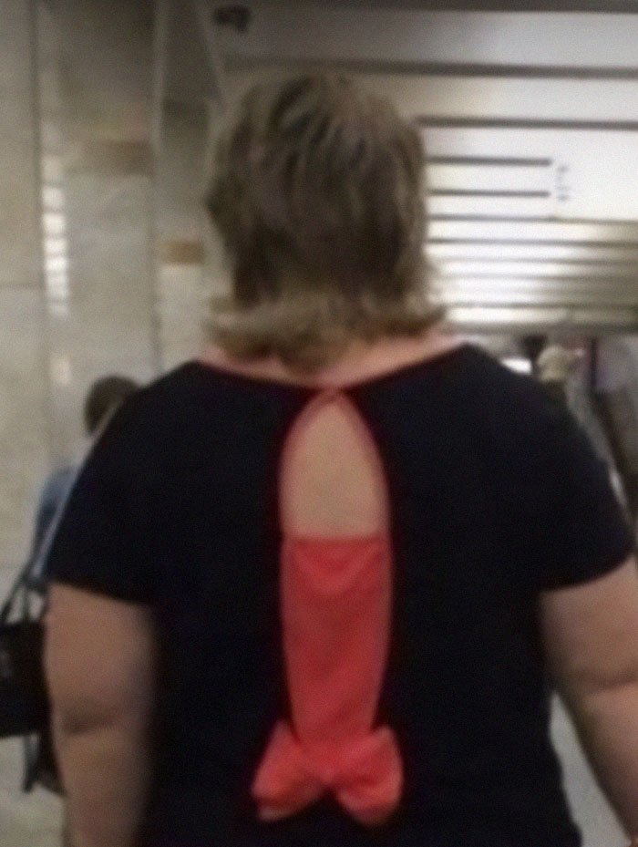 Mujer con camiseta negra y diseño de tela roja mal combinado causando uno de los fallos de diseño más divertidos.
