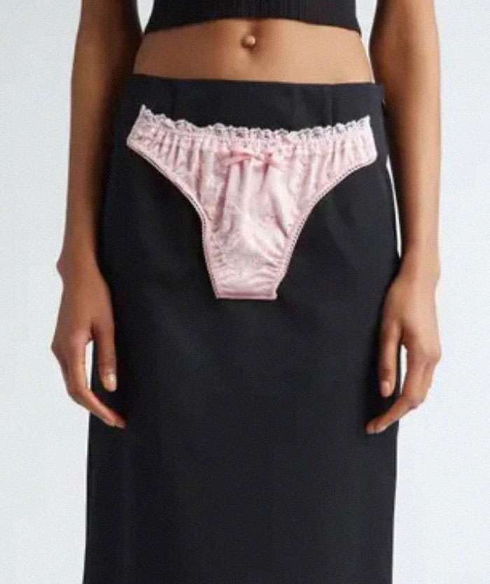 Falda negra con diseño de ropa interior rosa cosida al frente mostrando un fallo de diseño divertido y terrible.