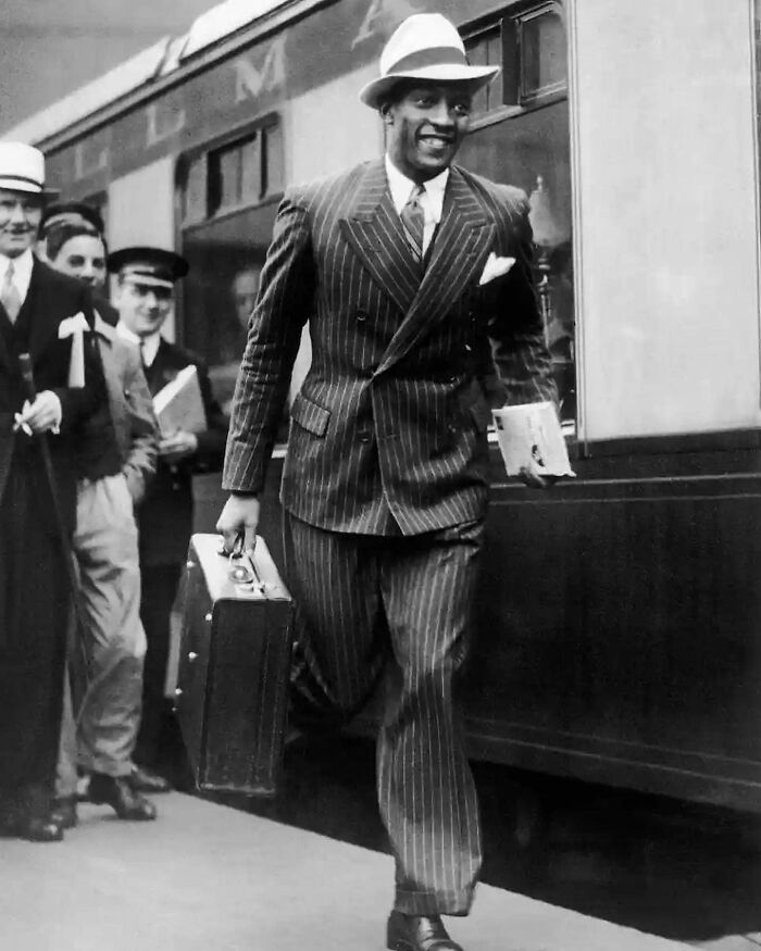 Hombre con traje caminando junto a tren en imagen histórica representando hechos y eventos poco conocidos del pasado. Hombre con traje caminando junto a tren en imagen histórica representando hechos y eventos poco conocidos del pasado.