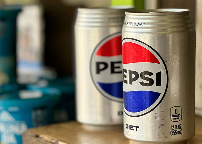 Lata de refresco Pepsi diet con gotas de condensación en foco frente a otra lata desenfocada, explotando vacíos legales.