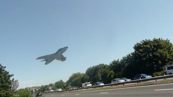 Avión bajando rápidamente sobre autopista llena de coches, momentos antes de un desastre impactante e inesperado.