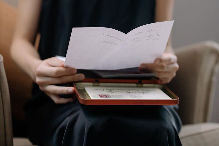 Persona leyendo carta, ilustrando padres cotillas descubriendo secretos de hijos adolescentes inesperadamente.