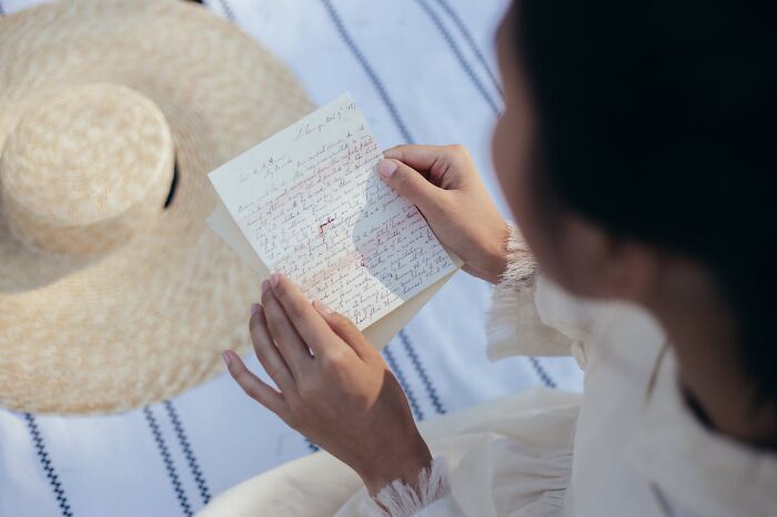Persona leyendo carta escrita a mano, ilustrando padres cotillas que descubren secretos de hijos adolescentes.