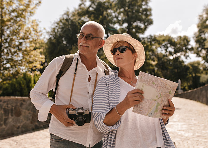 Pareja de turistas con cámara y mapa explorando al aire libre, símbolos de momentos donde se encontró maldad y sobrevivieron.