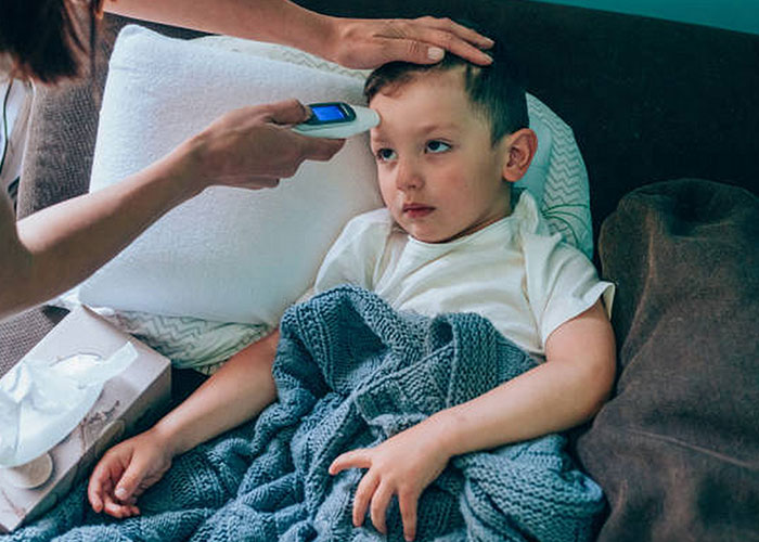 Niño enfermo recibiendo medición de temperatura, mostrando cómo sobrevivió encuentros con pura maldad según relatos reales.