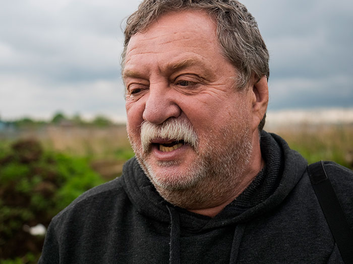 Hombre mayor con sudadera negra al aire libre, evocando historias sobre experiencias con un psicópata.