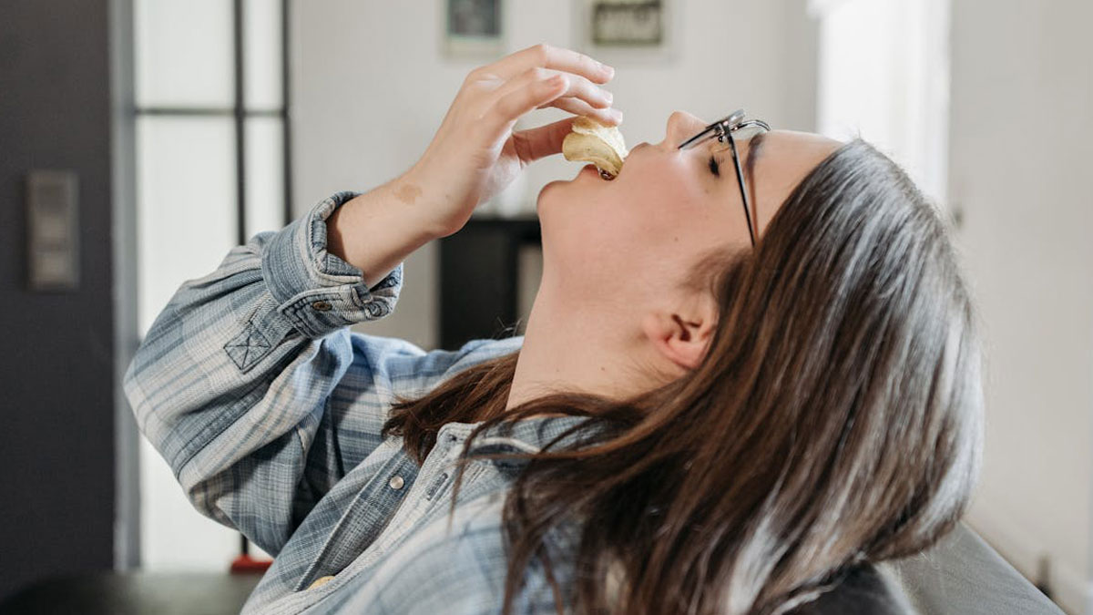 Mujer con gafas comiendo mientras reclina la cabeza, ilustrando pequeu00f1os secretos que nadie mu00e1s conoce.