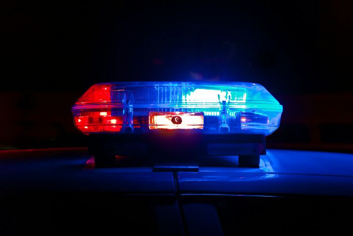 Luz de emergencia policial roja y azul encendida en la noche, mostrando situaciones no aptas para cardíacos en Reddit.