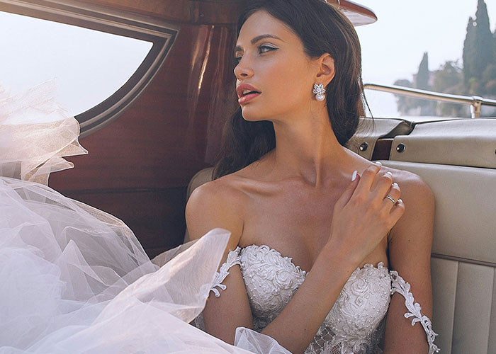 Mujer vestida de novia sentada en un automóvil, mostrando expresión pensativa relacionada con suegras difíciles.