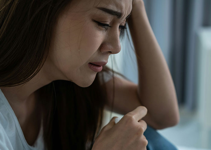 Mujer triste llorando, mostrando estrés y dificultad, reflejando lo que tienen que soportar con sus suegras.