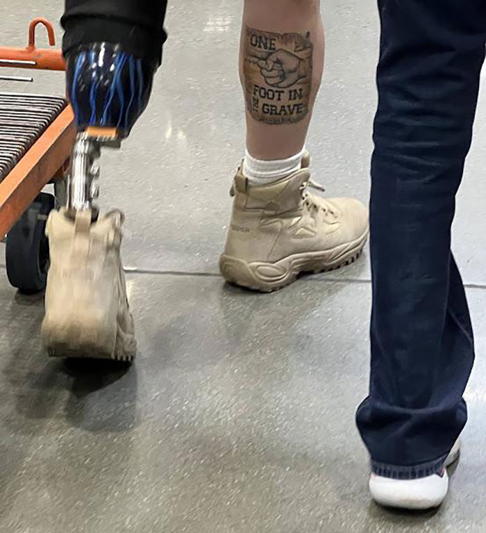Persona con pierna prostética y tatuaje creativo, mostrando humor ingenioso en una situación cotidiana con humor divertido.