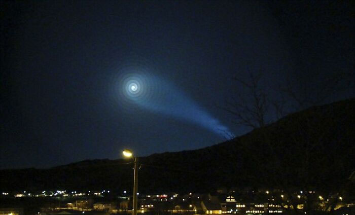 Objeto luminoso espiral en el cielo nocturno sobre un paisaje urbano, una de las fotos reales sin explicación hasta hoy.