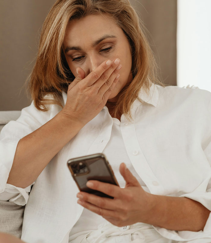 Mujer con expresión de shock mirando su teléfono móvil, mostrando cómo los teléfonos ayudan a descubrir verdades ocultas. Mujer con expresión de shock mirando su teléfono móvil, mostrando cómo los teléfonos ayudan a descubrir verdades ocultas.